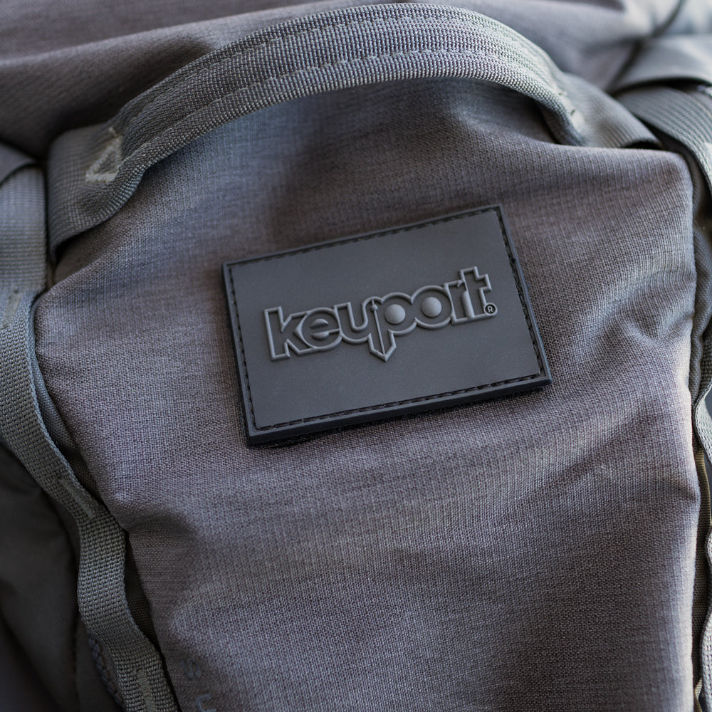 Dark grey on black 2x3 hook & loop Keyport logo tactical morale patch on EDC gear like bags, backpacks, and caps
