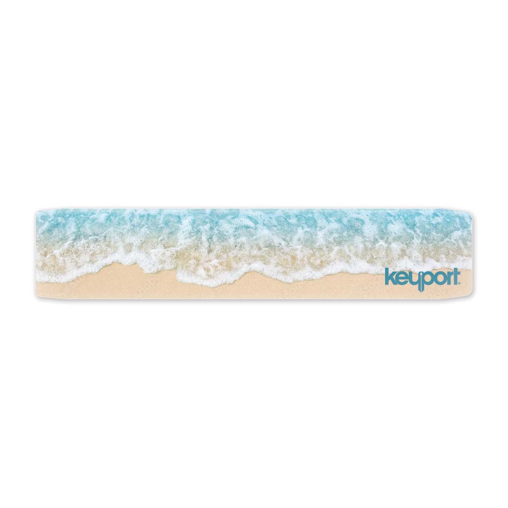 Keyport faceplate with a beach design, showing waves rolling onto a sandy shore
